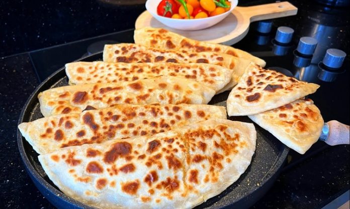 Gözleme Usulü Gelenekten Sofralara Taşınan Lezzet Gözleme, Türk mutfağının yüzyıllardır süregelen hamur işi lezzetlerinden biridir. Anadolu’nun her köşesinde farklı tariflerle hazırlanabilen gözleme, hem pratik hem de doyurucu oluşuyla bilinir. Geleneksel tariflerde kullanılan un ve su ile hazırlanan hamur, ince açılır ve çeşitli iç malzemelerle doldurulur. Konulu bir haber görseli.