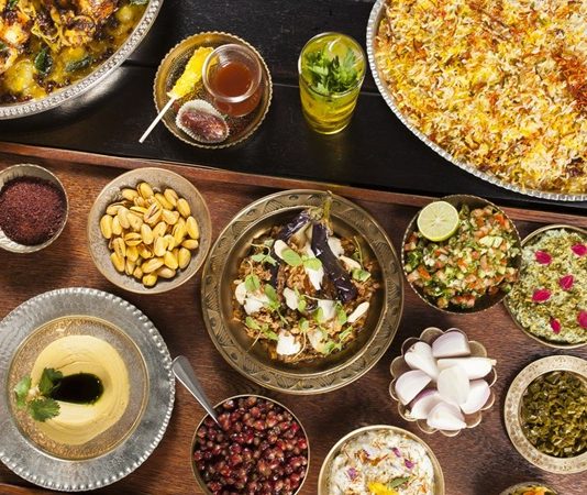 İran, tarih boyunca medeniyetlerin kavşak noktası olmuş bir coğrafyada yer alır ve bu durum mutfağına da yansımıştır. İran mutfağı, Pers, Arap, Türk ve hatta Akdeniz kültürlerinin birleşimiyle şekillenmiş, binlerce yıllık bir mirası taşır. Bu mutfak, baharatların ustaca kullanımı, et ve sebzelerin dengeli birleşimi ve aromatik tarifleri ile ön plana çıkar. Tarih boyunca farklı uygarlıklarla etkileşim, İran yemek kültürünü sadece lezzet açısından değil, aynı zamanda görsellik ve sunum açısından da zenginleştirmiştir. Konulu bir haber görseli.