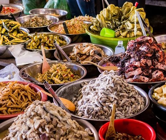 Kamboçya, Güneydoğu Asya’da Mekong Nehri ve Tonle Sap Gölü’nün kesişim noktasında yer alır. Bu stratejik konum, Kamboçya mutfağının hem Çin hem de Tayland mutfaklarından etkilenmesine olanak tanımıştır. Pirinç ve balık, mutfağın temel öğelerini oluştururken, taze otlar ve baharatlar yemeklere karakter kazandırır. Kamboçya mutfağı, hem geleneksel hem de modern öğeleri harmanlayarak zengin bir lezzet deneyimi sunar. Konulu bir haber görseli.