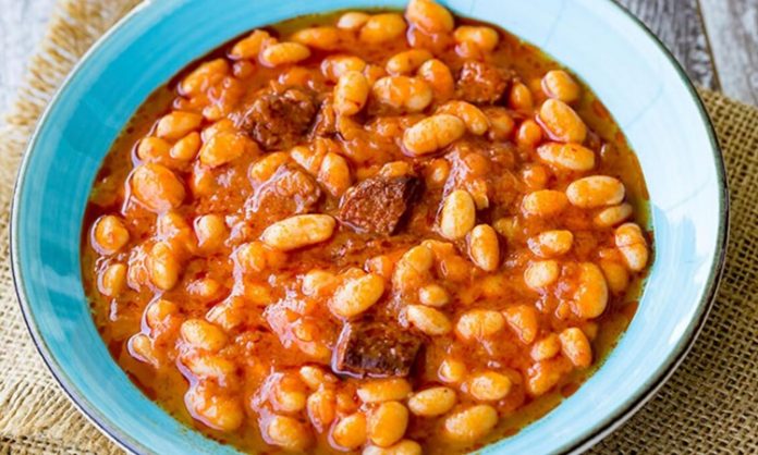 Türk mutfağının en sevilen yemeklerinden biri olan kuru fasulye, hem lezzeti hem de besleyici özellikleriyle sofralarda özel bir yere sahip. Yüzyıllardır Anadolu’nun dört bir yanında pişen bu klasik yemek, geleneksel tariflerden modern dokunuşlara kadar pek çok farklı şekilde hazırlanabiliyor. Özellikle bakliyatlar, uzun süre bozulmadan saklanabilmesi, yüksek protein ve lif içeriği ile hem ekonomik hem de sağlıklı bir besin kaynağı olarak öne çıkıyor. Konulu bir haber görseli.