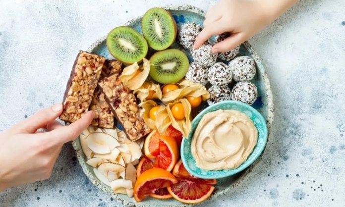 Modern yaşam temposu, çoğu zaman düzenli öğünler yerine ara öğünlerle beslenmeyi zorunlu kılıyor. Bu noktada sağlıklı atıştırmalıklar, hem enerji ihtiyacını karşılayan hem de dengeli beslenmeyi destekleyen önemli bir seçenek olarak öne çıkıyor. Günümüzde marketlerde, kafelerde ve hatta ofis mutfaklarında bu tür atıştırmalıkların çeşitliliği her geçen gün artıyor. Konulu bir haber görseli.