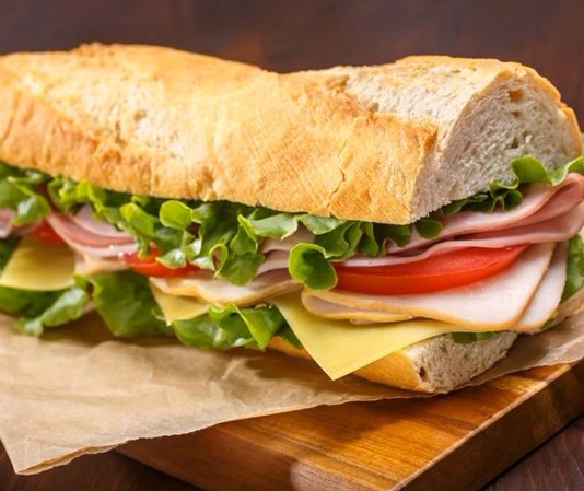 Günlük hayatın vazgeçilmez atıştırmalıkları arasında yer alan sandviç, hem pratik hazırlanışı hem de sınırsız malzeme kombinasyonlarıyla dünya mutfağında önemli bir yere sahiptir. Kahvaltıdan öğle yemeğine, akşam atıştırmalıklarından gece kaçamaklarına kadar günün her anına uyum sağlayan bu lezzet, kültürden kültüre farklı yorumlarla sofralarda yer bulur. Konulu bir haber görseli.