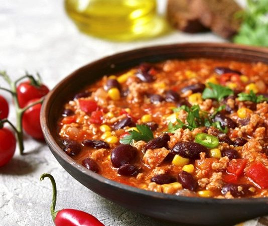 Chili Con Carne Dünyanın En Baharatlı Lezzetlerinden Biri Chili Con Carne, Meksika ve Amerika mutfaklarının kesişim noktasında doğmuş, dünya genelinde tanınan baharatlı bir yemektir. İsminin anlamı “etli biber” olup, temelinde kırmızı biber ve dana eti yer alır. Kökeni konusunda farklı tartışmalar bulunsa da genellikle Meksika kökenli olduğu kabul edilir. Ancak Texas mutfağının da bu yemeğin yaygınlaşmasında büyük payı vardır. Konulu bir haber görseli.