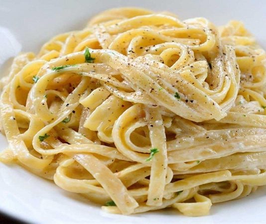 Fettucine Alfredo, İtalyan mutfağının kremalı makarna klasikleri arasında yer alır ve özellikle tereyağı ve parmesan peyniri ile hazırlanan sosuyla tanınır. Makarna, geniş ve düz fettucine hamurundan yapılır, bu sayede sosu iyice emerek kremamsı bir dokuyu elde eder. Konulu bir haber görseli.