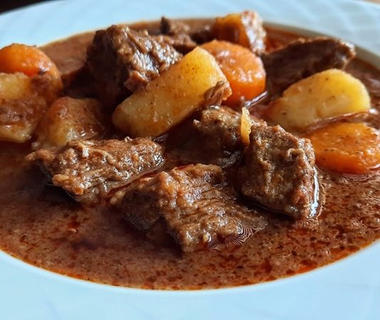 Gulaş, Orta Avrupa mutfağının en bilinen yemeklerinden biridir. Macaristan’da doğan bu yemek, yüzyıllar boyunca farklı bölgelerin damak zevklerine göre şekillenmiştir. Kökeni 9. yüzyıla kadar uzanan gulaş, ilk olarak çobanların hazırladığı etli bir yahniydi. Etin dayanıklı kalması ve uzun süre tok tutması için ateşin üzerinde ağır ağır pişirilmesi, yemeğin en karakteristik özelliğini oluşturmuştur. Zamanla baharatların ve sebzelerin eklenmesiyle birlikte gulaş sadece bir çoban yemeği olmaktan çıkıp aristokrat sofralarına kadar taşınmıştır. Konulu bir haber görseli.