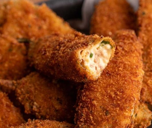 Jalapeno Popper: Baharatlı Atıştırmalık Tutkusu Jalapeno popper, özellikle Amerika ve Meksika mutfağında öne çıkan, baharatlı ve peynir dolgusuyla dikkat çeken bir atıştırmalıktır. Bu lezzetli yiyecek, adını ana malzemesi olan jalapeno biberlerinden alır ve genellikle içi krem peynir veya cheddar ile doldurulur. İlk olarak 1980’lerde popülerleşen jalapeno popper, kısa sürede fast food restoranları ve ev mutfaklarının favori atıştırmalıkları arasında yerini almıştır. Konulu bir haber görseli.