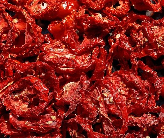 Kurutulmuş domates, mutfaklarda giderek daha fazla tercih edilen sağlıklı ve doğal ürünlerden biridir. Taze domateslerin özel yöntemlerle suyunun çekilmesi ve güneşte ya da düşük sıcaklıkta kurutulmasıyla elde edilir. Böylece domatesin besin değerleri korunur, aroması yoğunlaşır ve daha uzun süre saklanabilir hale gelir. Doğal yapısı sayesinde hem geleneksel hem de modern tariflerde kullanılabilen kurutulmuş domates, sofralara farklı bir tat ve zenginlik katar. Konulu bir haber görseli.