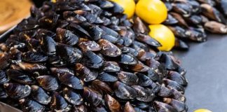 Midye Dolma: Denizden Sofralara Lezzetli Atıştırmalık Midye dolma, taze midyelerin pirinç, soğan, baharat ve bazen etle doldurularak hazırlanan geleneksel bir deniz ürünü yemeğidir. Özellikle Karadeniz ve Ege mutfağında sıkça rastlanan bu lezzet, hem sokak lezzeti hem de ev yemeği olarak tüketilmektedir. Midyenin doğal tuzluluğu ve dolgun iç harcı, yemeğe kendine has bir aroma katar. Konulu bir haber görseli.