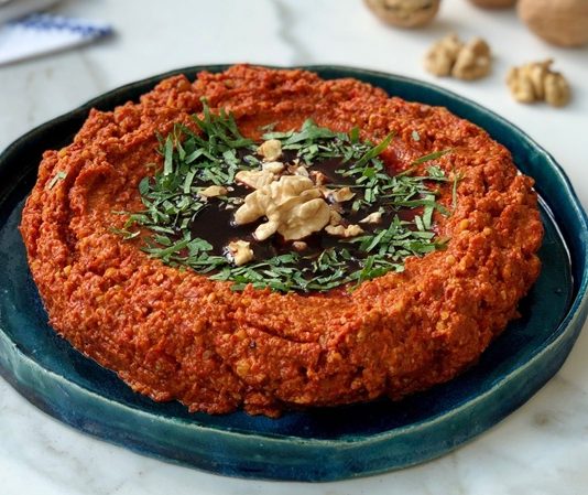 Muhammara, özellikle Akdeniz ve Orta Doğu mutfaklarının sevilen mezelerinden biridir. Muhammara, kırmızı biber, ceviz ve zeytinyağı ile hazırlanan, hem lezzetli hem de besleyici bir mezedir. İçerdiği sağlıklı yağlar ve proteinler sayesinde hem enerji verir hem de vücut sağlığını destekler. Ceviz, özellikle omega-3 açısından zengin olmasıyla kalp sağlığını desteklerken, kırmızı biberin içerdiği vitaminler bağışıklık sistemini güçlendirir. Konulu bir haber görseli.