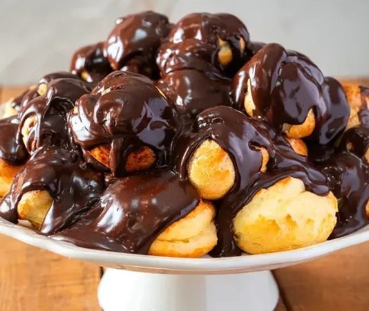 Profiterol, Fransız mutfağından çıkmış, ince ve hafif hamurun içine krem doldurularak yapılan bir tatlıdır. İlk olarak 16. yüzyılda Fransa’da ortaya çıkan bu lezzet, kısa sürede Avrupa’nın farklı bölgelerine yayılmıştır. Hafif yapısı ve şık sunumuyla profiterol, özel günler ve davet sofralarının vazgeçilmezi haline gelmiştir. Konulu bir haber görseli.