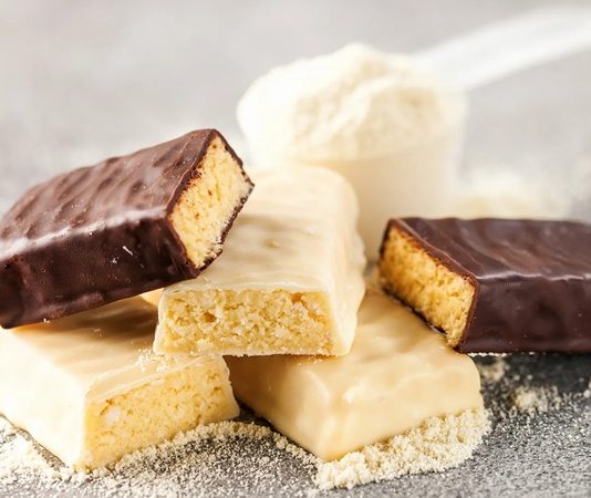 Günümüzde protein barlar, sporcular, yoğun çalışanlar ve sağlıklı beslenmeyi tercih eden kişiler arasında giderek popülerleşiyor. Bu barlar, pratik ve taşınabilir yapıları sayesinde, hızlı enerji ve protein ihtiyacını karşılamak için ideal bir seçenek sunuyor. Protein barlar, özellikle spor sonrası kas onarımı ve tok kalma süresi açısından önemli bir rol oynuyor. Konulu bir haber görseli.