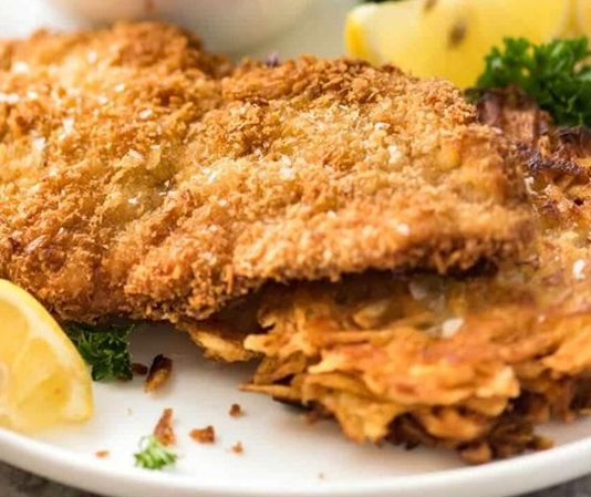 Schnitzel, Almanya ve Avusturya mutfaklarının en bilinen yemeklerinden biridir. İnce dilimlenmiş etin pane harcıyla kaplanıp kızartılmasıyla elde edilen bu lezzet, hem sokak yemekleri hem de restoran menülerinde sıklıkla yer alır. İsmi Almanca “dilim” anlamına gelen “Schnitt” kelimesinden türemiştir ve geleneksel olarak dana veya tavuk eti kullanılır. Konulu bir haber görseli.