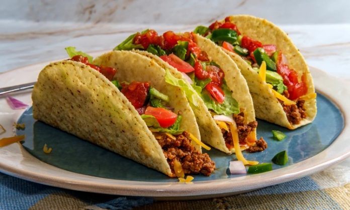 Taco Meksika Mutfağının Efsane Sokak Lezzeti Taco, Meksika mutfağının en bilinen ve sevilen sokak lezzetlerinden biridir. Mısır veya buğday bazlı tortilla içine çeşitli malzemelerin doldurulmasıyla hazırlanır. Tarihi, yüzyıllar öncesine dayanan taco, Meksika halkının günlük beslenmesinde önemli bir yere sahiptir. Konulu bir haber görseli.