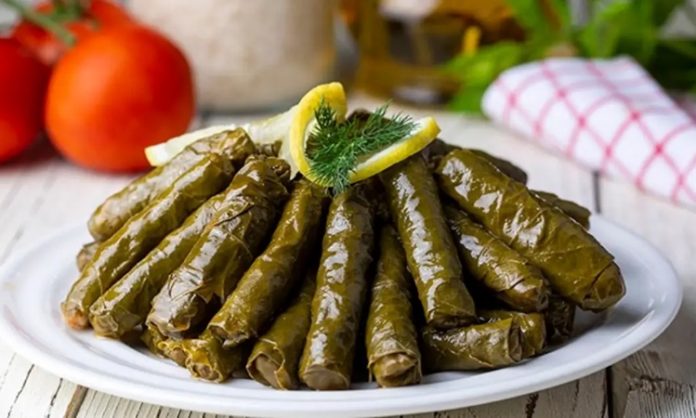 Zeytinyağlı Yaprak Sarma Sofraların Vazgeçilmez Lezzeti Zeytinyağlı yaprak sarma, Türk mutfağının en sevilen geleneksel lezzetlerinden biridir. Özellikle meze olarak sofralarda sıkça yer alır ve hem hafif hem de besleyici bir alternatif sunar. Yaprak sarması, sadece Türkiye’de değil, Orta Doğu ve Balkan mutfaklarında da farklı yorumlarla hazırlanır. Konulu bir haber görseli.