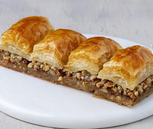 Türkiye’nin geleneksel tatlı kültürünün en önemli temsilcilerinden biri olan cevizli baklava, son dönemde hem yurt içinde hem de yurt dışında yeniden büyük bir ilgi görmeye başladı. Asırlardır bayramların, düğünlerin ve özel günlerin vazgeçilmez tatlısı olan cevizli baklava, özellikle el açması yufka, kaliteli ceviz ve özenle hazırlanan şerbetiyle Türk mutfağının en güçlü lezzet simgeleri arasında yer alıyor. Günümüzde baklava üreticilerinin çeşitliliği artırması, geleneksel tariflere sahip çıkması ve modern sunum teknikleri geliştirmesi, tatlının bilinirliğini daha da yükseltti. Konulu bir haber görseli.