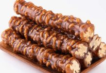 Anadolu mutfağının en sevilen geleneksel tatlarından biri olan cevizli sucuk, özellikle kış aylarının yaklaşmasıyla yeniden gündemde. Doğal içeriği, uzun süre saklanabilmesi ve hem atıştırmalık hem de enerji verici bir yiyecek olarak tüketilmesi, onu her yıl olduğu gibi bu yıl da yoğun ilgi gören bir ürün hâline getiriyor. Üzüm şırasının yoğunlaştırılmasıyla elde edilen karışımın ceviz dizilmiş ipe özenle geçirilip kat kat işlenmesi, bu tatlıyı sadece bir yiyecek olmaktan çıkarıp kültürel bir mirasa dönüştürüyor. Son dönemde yerel üreticilerin doğal yöntemlere dönüş yapmasıyla birlikte cevizli sucuk hem şehir pazarlarında hem de online satışlarda gittikçe daha görünür hâle geliyor. Konulu bir haber görseli.