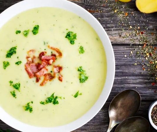 Kremalı Patates Çorbası Soğuk Günlerin En Sevilen Sıcak Lezzeti Oluyor Kış aylarının gelmesiyle birlikte sıcak çorbalara olan ilgi yeniden artış göstermeye başladı. Özellikle yumuşak dokusu, hafifliği ve doyuruculuğuyla öne çıkan kremalı patates çorbası, hem ev mutfaklarında hem de restoran menülerinde sıkça tercih edilen tarifler arasında yer alıyor. Patatesin doğal tadının krema ile birleşmesi, çorbaya hem pürüzsüz bir kıvam hem de zengin bir aroma kazandırıyor. Bu nedenle özellikle yoğun iş temposuna sahip kişiler, pratik ve besleyici bir başlangıç aradıklarında sıklıkla kremalı patates çorbası hazırlamayı tercih ediyor. Konulu bir haber görseli.