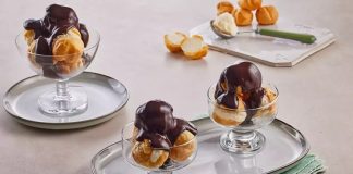 Profiterol Tatlı Dünyasında Zarif Bir Klasiğe Dönüşüyor Fransız mutfağının en seçkin tatlılarından biri olan profiterol, uzun yıllardır hem restoranların hem de ev mutfaklarının en sevilen lezzetlerinden biri olarak yerini koruyor. Çıtır hamurun içindeki hafif krema ve üzerine dökülen yoğun çikolata sosuyla oldukça cezbedici bir tat sunan profiterol, özellikle misafir ağırlamalarında şık bir sunum oluşturmasıyla ön plana çıkıyor. Günümüzde pastane vitrinlerinde sıkça görülen bu tatlı, son dönemde ev yapımı tariflerin popülerleşmesiyle birlikte mutfakta daha da yaygın şekilde hazırlanıyor. Konulu bir haber görseli.