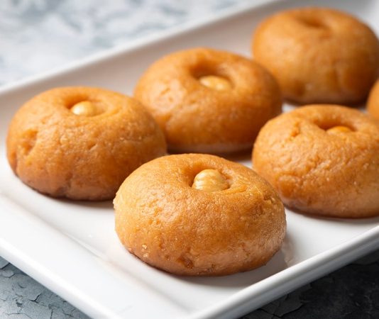 Türk mutfak kültürünün en özel tatlılarından biri olan şekerpare, hem zarif görüntüsü hem de ağızda dağılan kıvamıyla uzun yıllardır sofralardan eksik olmayan bir lezzet olarak varlığını sürdürüyor. Osmanlı döneminden bu yana tatlı geleneğinin önemli bir parçası olan şekerpare, özellikle bayram sofraları, misafir ağırlamaları ve özel davetlerin vazgeçilmez tatlıları arasında yer alıyor. Tatlının yumuşak dokusu, ölçülü tatlılığı ve pratik hazırlanışı, onun yıllar içinde daha da sevilen bir klasik hâline gelmesini sağladı. Konulu bir haber görseli.