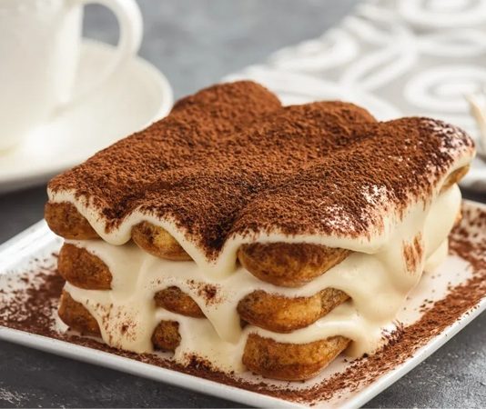 İtalyan mutfağının dünya çapında en bilinen tatlılarından biri olan tiramisu, sadece hafifliğiyle değil içinde barındırdığı zengin aromalarla da her yaştan insanın damak zevkine hitap etmeyi başarıyor. İlk bakışta yumuşak yapısı ile dikkat çeken tiramisu, kahve aromalı bisküvileri ve mascarpone kreması sayesinde kendine özgü bir tat profili oluşturuyor. Bugün birçok pastane ve restoran menüsünde yer alan tiramisu, hem geçmişten gelen kültürel özellikleri hem de modern yorumlarıyla öne çıkmayı sürdürüyor. Konulu bir haber görseli.